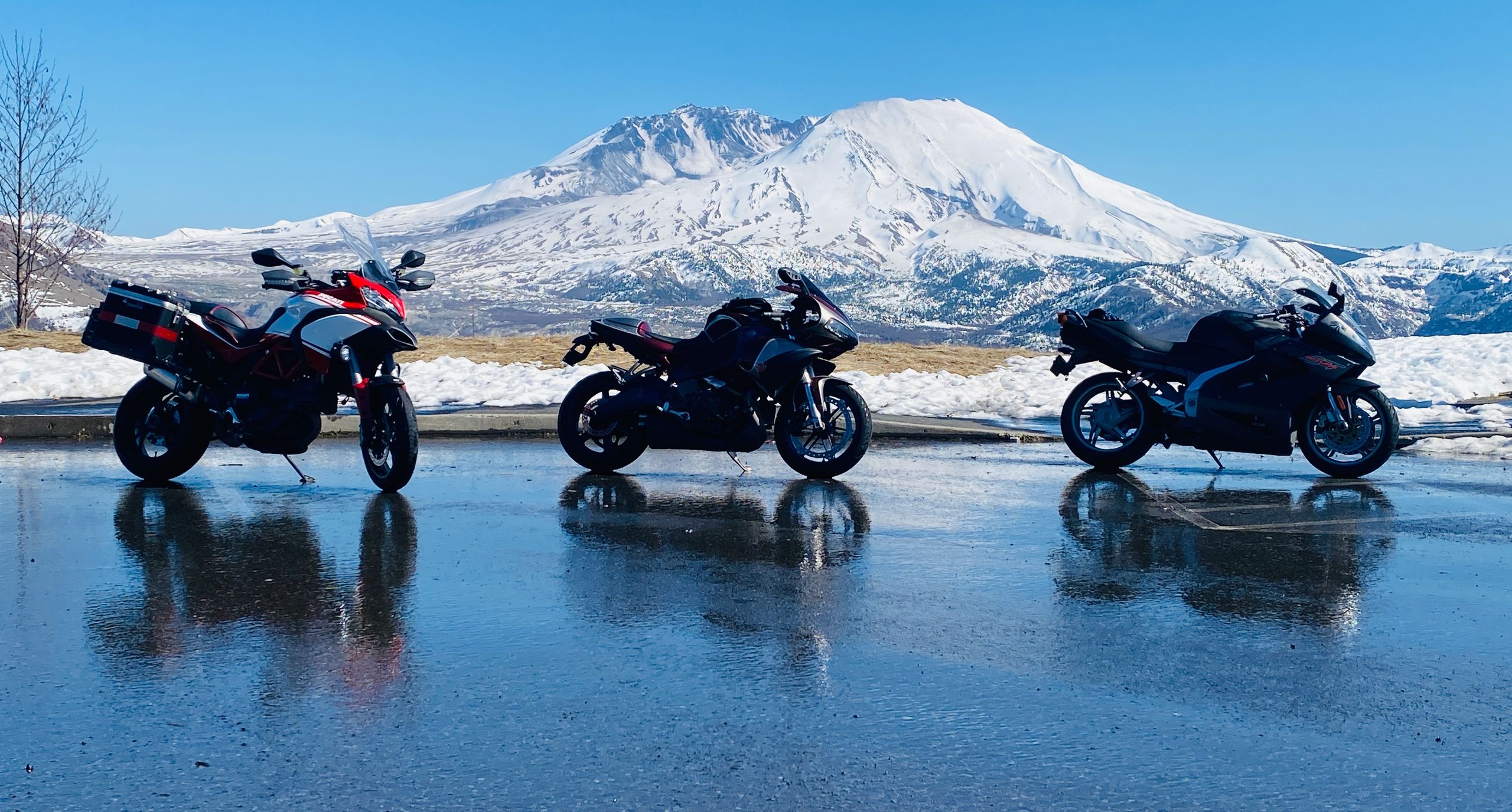 Motorcycles parked in front of a snow-capped mountain